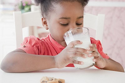girl drinking milk with a cookie
