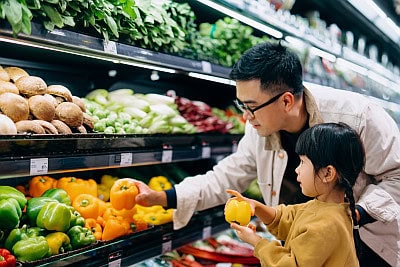 father and daughter shopping in grocery store