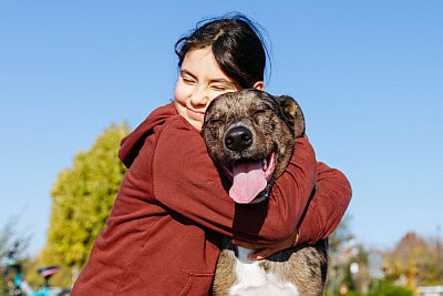 girl hugging dog