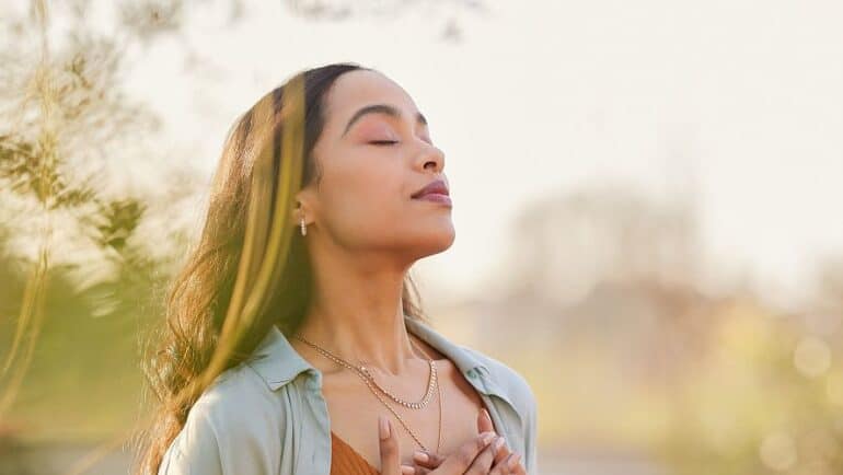 woman meditating and breathing outside