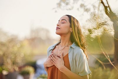 woman outside breathing and meditating