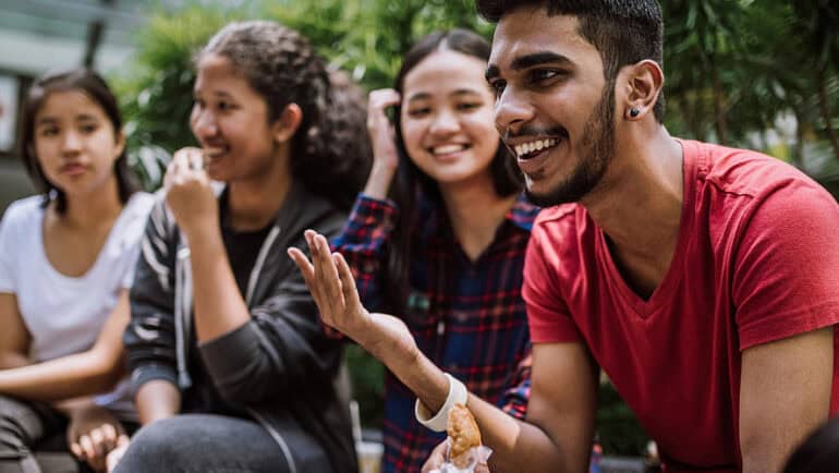 college students talking and laughing on campus